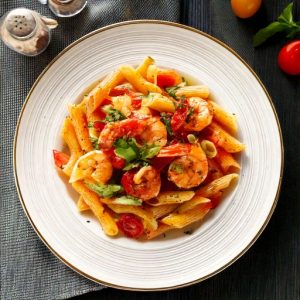 Rigatoni au pesto de tomates séchées et légumes du jardin, garni de crevettes à l’ail