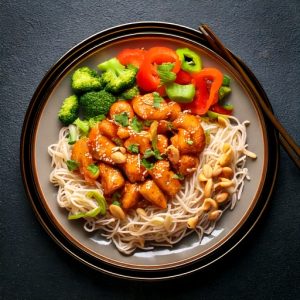 Poulet à l’arachide sur nouille de riz et légumes
